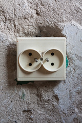 Dual socket on the old, destroyed wall.