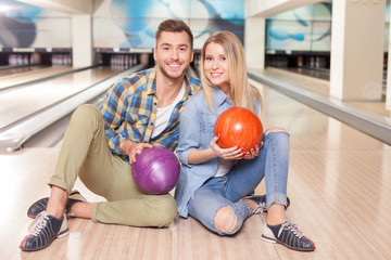 Fototapeta premium Cheerful young loving couple in kegling club