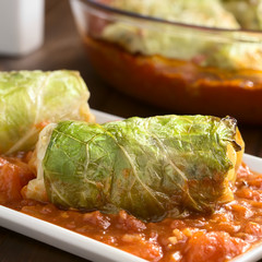 Vegetarian baked stuffed savoy cabbage roll filled with wholegrain rice, pepper, onion and carrot, photographed with natural light (Selective Focus)