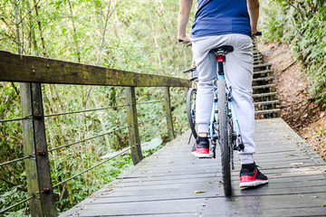 Young man cycling in the forest trail in cold weather during weekend