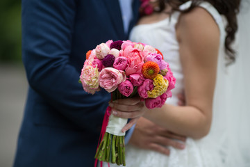 Wedding bouquet of freshly cut flowers closeup with bride and gr