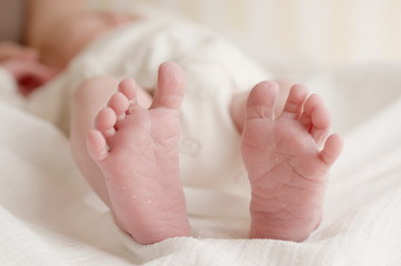 Newborn baby feet on white cloth diaper horizontal