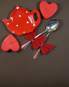 A pair of spoons with red ribbon and two hearts and red plate , Valentine's Day
