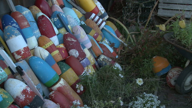Pan across stacked striped fishing buoys in Massachusetts.