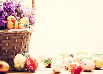 Colorful hand painted Easter eggs in basket and on wood. Handmade vintage decoration