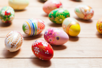 Fototapeta na wymiar Colorful hand painted Easter eggs on wood. Unique handmade, vintage design.