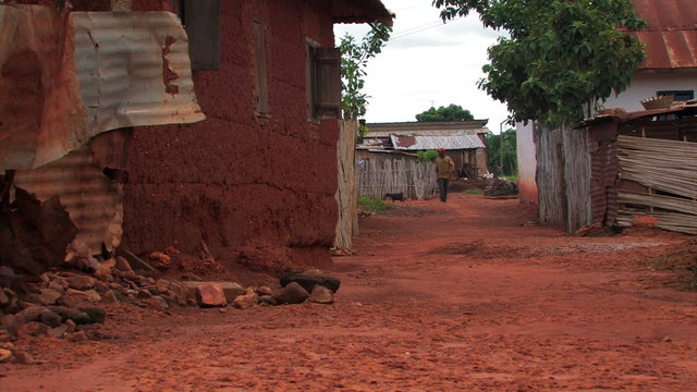 Man walking down a street in an African town.