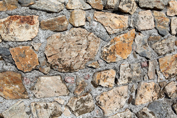 Старая каменная стена из желтого и коричневого камня. фоновая текстура