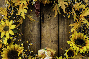 autumn wreath made of sunflowers and fall leaves on wood wall background - Powered by Adobe