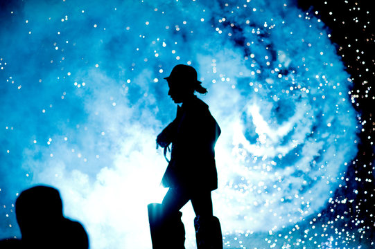 Silhouette of a performer during a shown with fireworks