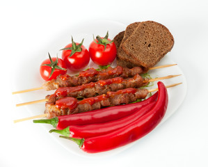 Shish kebab with herbs on a white plate