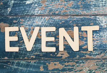 Word event written with wooden letters on rustic surface
