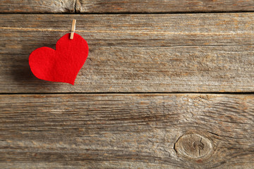 Love heart hanging on rope on a grey wooden background