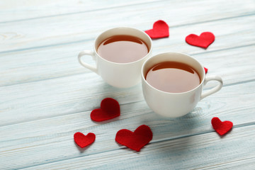 Love hearts with cups of tea on a blue wooden table