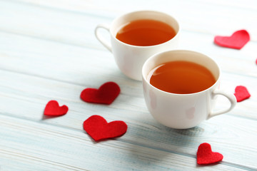 Love hearts with cups of tea on a blue wooden table