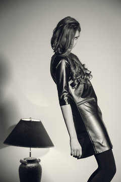 Young seductive woman in a black leather dress
