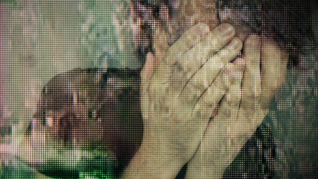 Psychotic bearded man with mental problems, low key portrait in dark room, overlaying digital tv glitch video