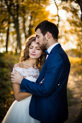 Fairytale romantic valentyne newlywed couple hugging and posing under old castle bridge at sunset in autumn closeup