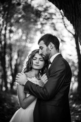 Fairytale romantic valentyne newlywed couple hugging and posing under old castle bridge at sunset in autumn b&w
