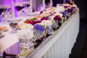 Obraz na płótnie Canvas Flowers closeup at wedding reception table in purple colors