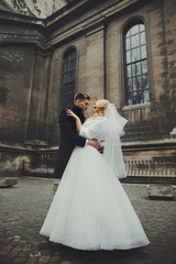 Obraz premium Gorgeous newlywed bride in white coat and handsome groom valenty