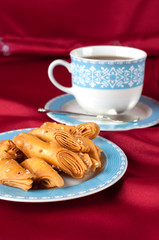 Puff pastry with sesame seeds on a blue cup.
