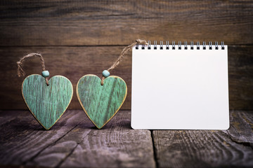 Green Wooden Hearts With Blank White Notepad On Wooden Board. Love Concept.