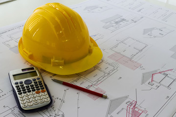 Scrivania d'ufficio con elaborati di progetto e casco di protezione