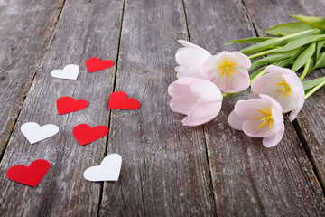 Valentines Day background with red and white hearts, flowers tulips on red box and old wooden background. text space