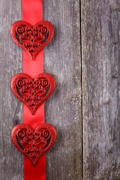 Valentines Day background - big hearts on red ribbon on wooden background. Text space