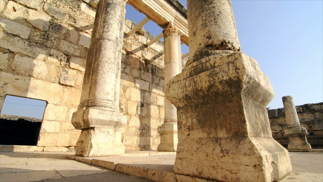 Slow-moving tracking footage of crumbling columns in courtyard