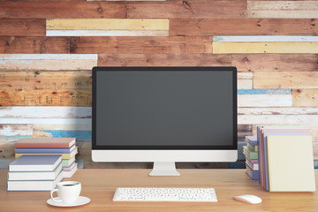 Blank screen on the desktop computer with books and cup of coffe