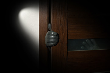 man's hand in a black glove open the door