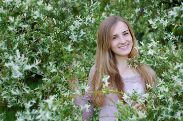 beautiful happy woman in blossoming spring garden on a warm day