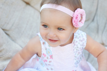 Cheerful little girl sitting on the white chair