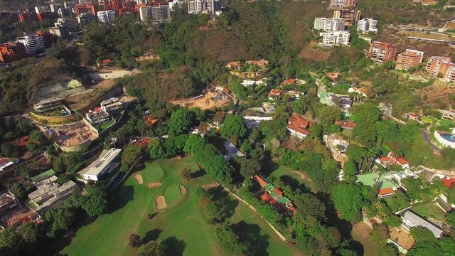 Aerial view of a residential district overflight on a capital city. Golf Course.