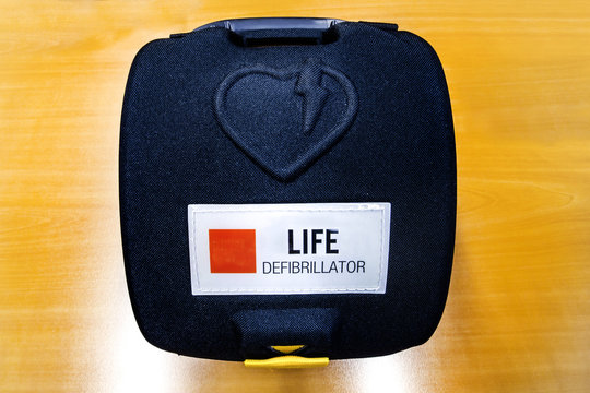 Automatic External hart defibrillator pack on the wooden color o