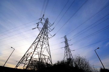 High voltage transmission towers against blue sky