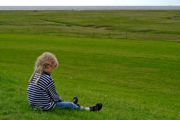 Kleines Mädchen auf Wiese am Meer