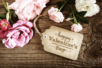 Valentines message with pink roses on wooden table