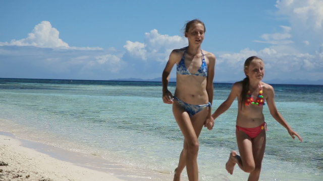 Two girls walking on a tropical beach