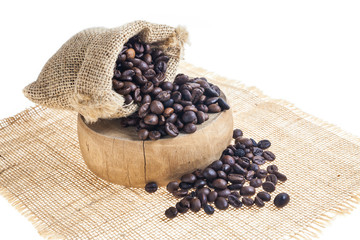Coffee beans in sack on wooden cutting board.