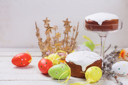 Easter cakes, colorful easter eggs, willow branches on white woo