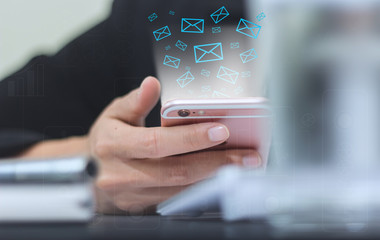 soft focus of Hand of a businessman holding a phone icon appears on the screen of the phone.