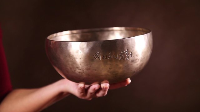 Tibetan singing bowl being made to sing in one's hand
