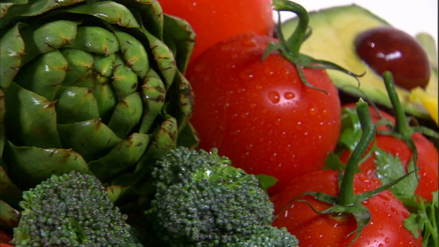 Rotating assortment of vegetables on a white screen.