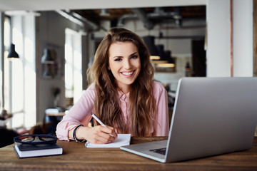 Young woman working with laptop at coffee shop