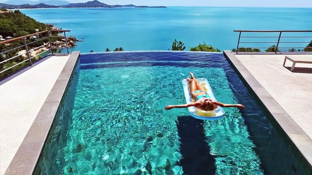 Young girl swims in the pool