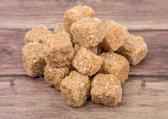 Brown sugarcane sugar cube over wooden background