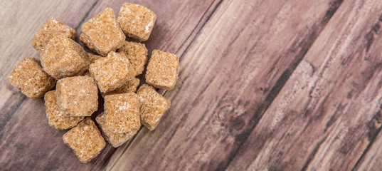 Brown sugarcane sugar cube over wooden background